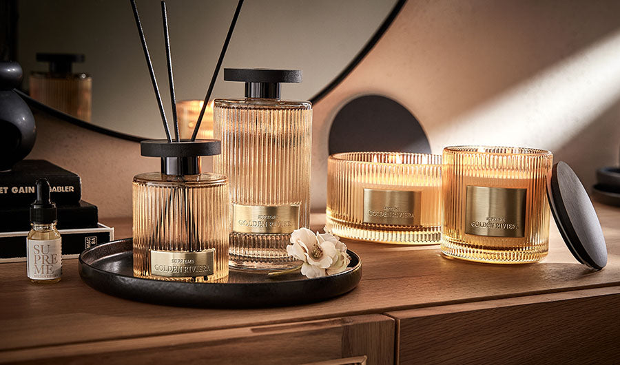 Goldene Duftserie mit Diffuser und Kerzen auf Tablett