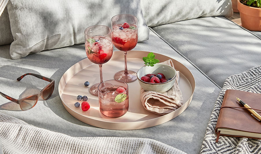 Rosa Metalltablett mit Beerencocktail-Gläsern im Freien
