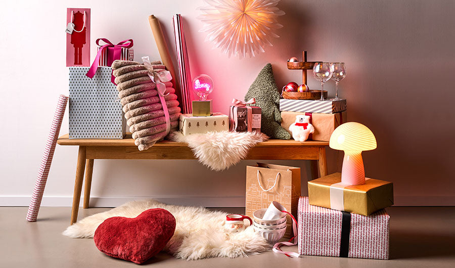 Weihnachtsgeschenke mit Neon-Liebe-Lampe auf Holzbank