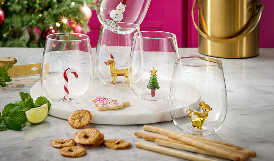 Weihnachtsgläser mit Glasfiguren wie Reh und Zuckerstange auf Marmor