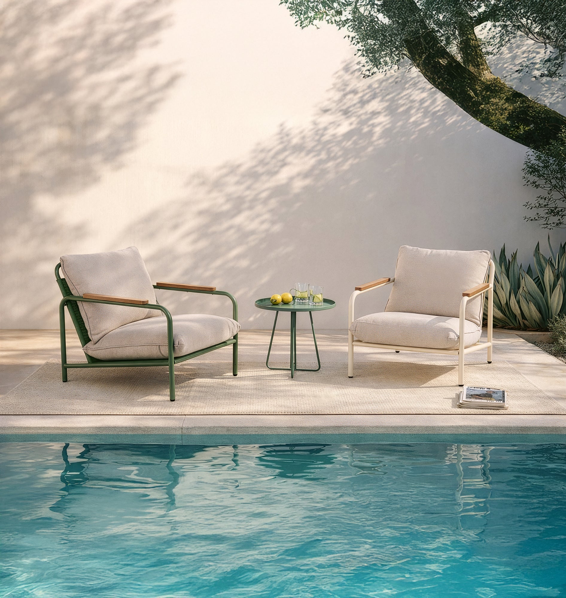 Exklusive Gartenlounge Möbel mit zwei Sesseln in Beige und Grün sowie einem kleinen Beistelltisch direkt am Pool für echtes Urlaubsflair.