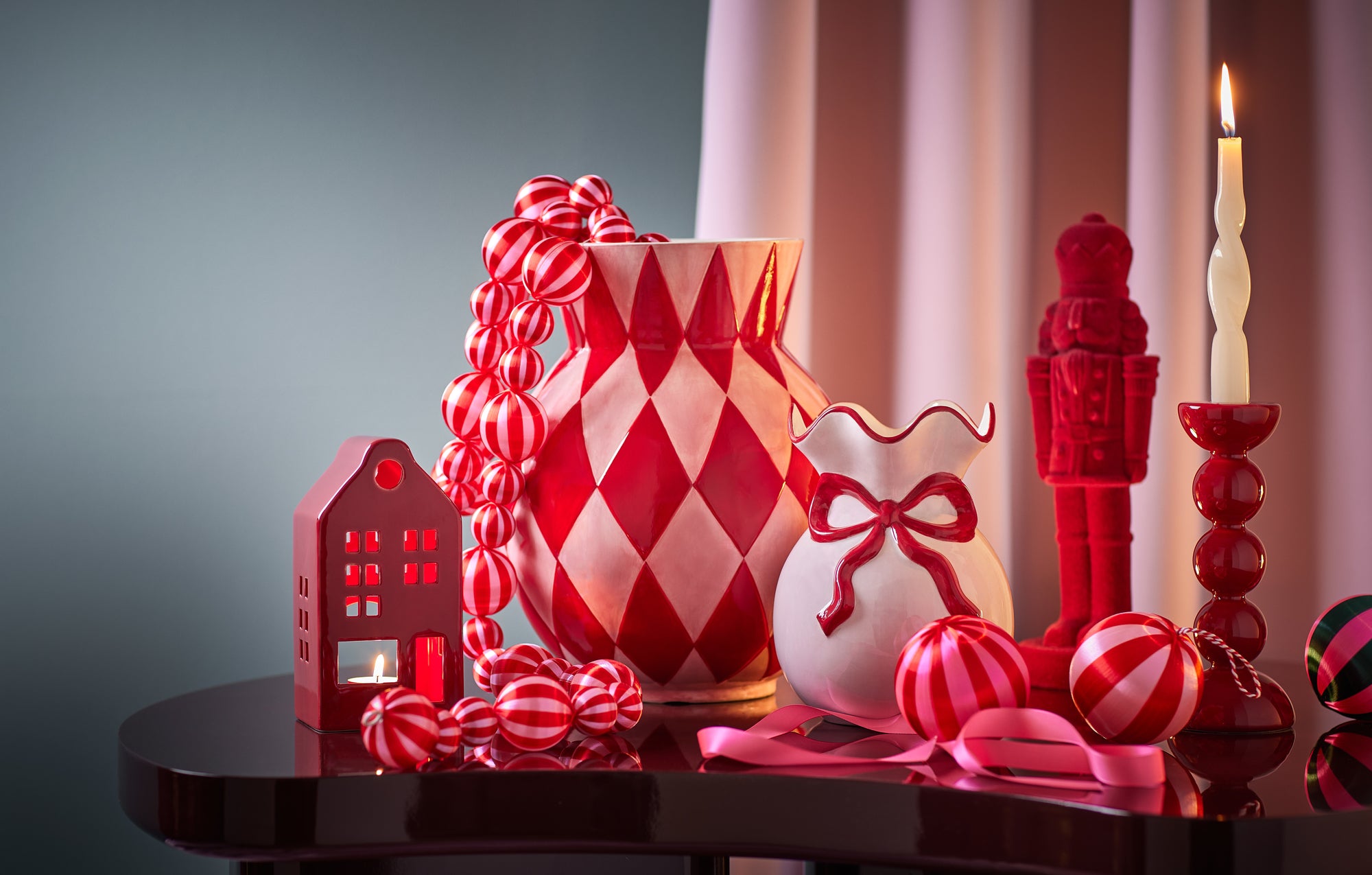 Rote Weihnachtsdeko mit Vasen, Weihnachtskugeln, Nussknacker und Teelichthaus
